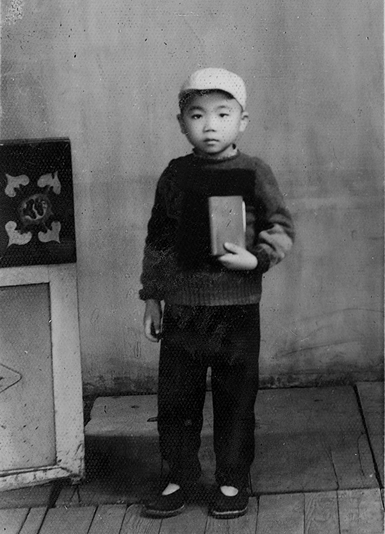 4歳の時、毛沢東語録を手にしている